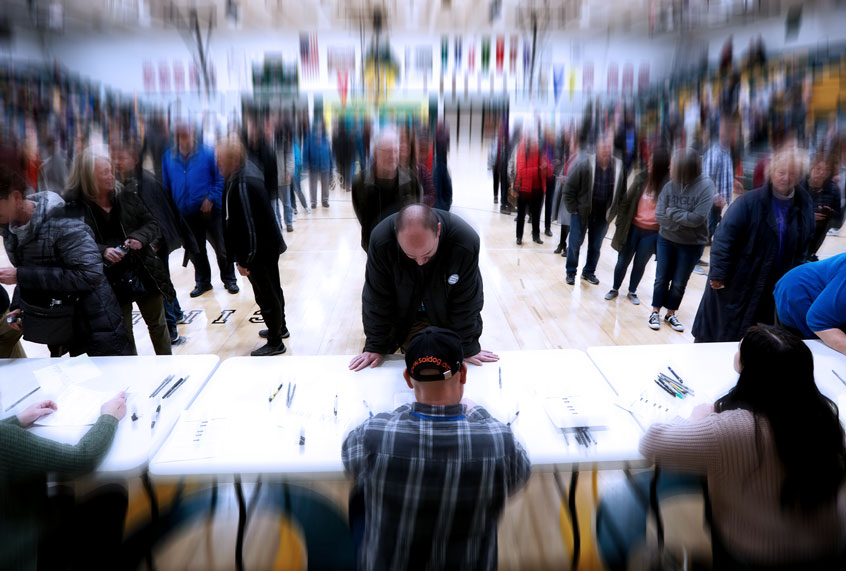 Local residents check-in after arriving at an Iowa Democratic caucus at Hoover High School, Monday, Feb. 3, 2020, in Des Moines, Iowa. (AP Photo/Charlie Neibergall)