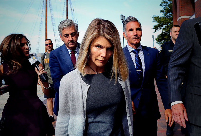 Lori Loughlin, center, and her husband Mossimo Giannulli, behind her at right, leave the John Joseph Moakley United States Courthouse in Boston on Aug. 27, 2019. A judge says actress Lori Loughlin and her fashion designer husband, Mossimo Giannulli, can continue using a law firm that recently represented the University of Southern California. The couple appeared in Boston federal court on Tuesday to settle a dispute over their choice of lawyers in a sweeping college admissions bribery case. Prosecutors had said their lawyers pose a potential conflict of interest. Loughlin and Giannulli say the firms work for USC was unrelated to the admissions case and was handled by different lawyers. (John Tlumacki/The Boston Globe via Getty Images)