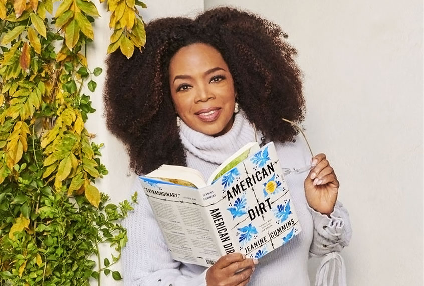 Oprah holding "American Dirt" by Jeanine Cummins (Apple)