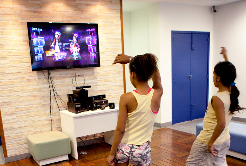 Poor children from favela Complex Alemao dance to an Xbox game in a community center, on September 13, 2012 in Rio de Janeiro, Brazil. (Melanie Stetson Freeman/The Christian Science Monitor via Getty Images)