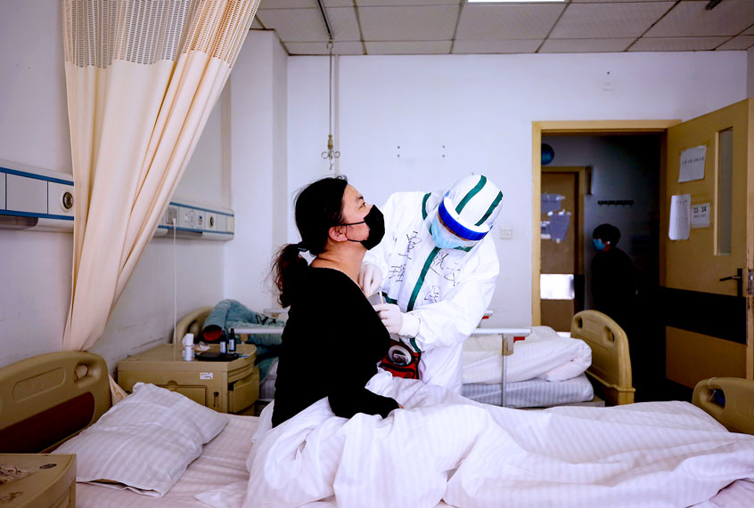 A medical worker of Yao ethnic medicine performs acupuncture on the neck of a COVID-19 patient in a hospital in Wuhan in central China's Hubei province Wednesday, March 11, 2020. The Chinese health authority has encouraged the usage of traditional Chinese medicine on patients after the outbreak. (Feature China/Barcroft Media via Getty Images)