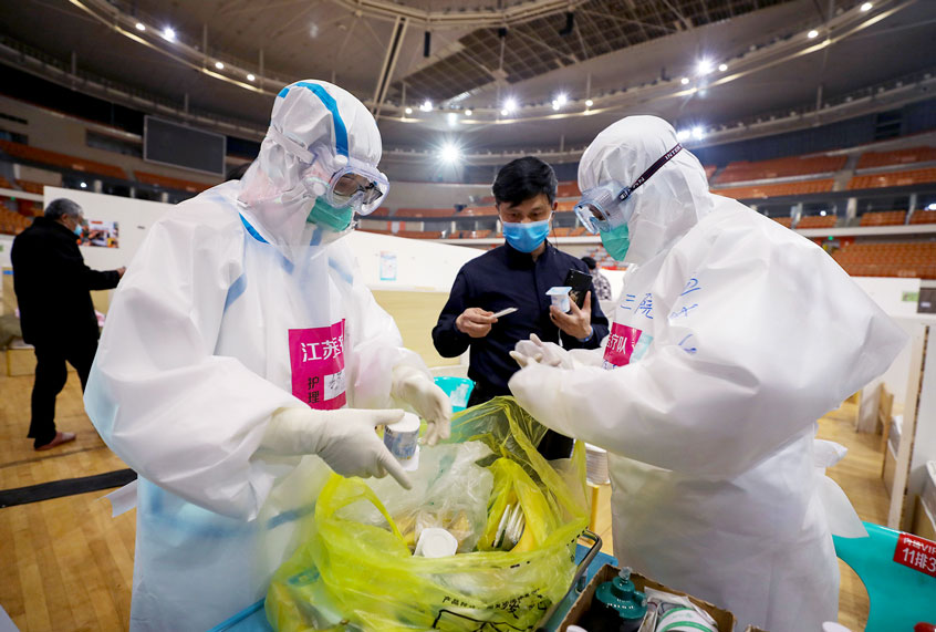 This photo taken on March 5, 2020 shows nurses preparing to deliver yoghurt to patients at a temporary hospital set up for COVID-19 coronavirus patients in a sports stadium in Wuhan, in China's central Hubei province. - China reported 30 more deaths from the new coronavirus outbreak on March 6, with fresh infections rising for a second straight day and 16 new cases imported from overseas. (STR/AFP via Getty Images)