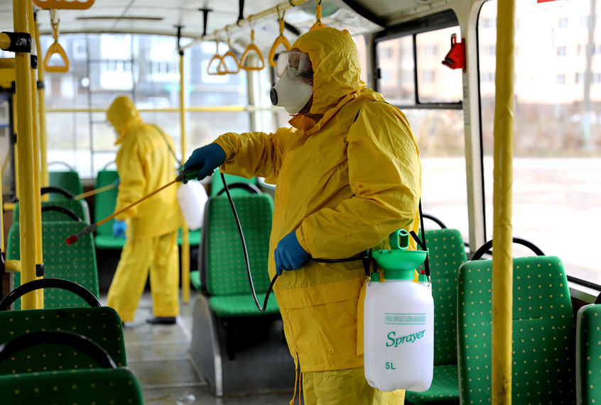 Employees wearing protective gear spray disinfectant to sanitize a passenger bus as a preventive measure against the coronavirus in Lviv, Ukraine, Tuesday, March 3, 2020. Ukrainian Chief sanitary and epidemiological doctor Viktor Liashko has just reported its first confirmed case of the new COVID-19 coronavirus, saying a man who recently arrived from Italy was diagnosed with the virus. (AP Photo/Mykola Tys)