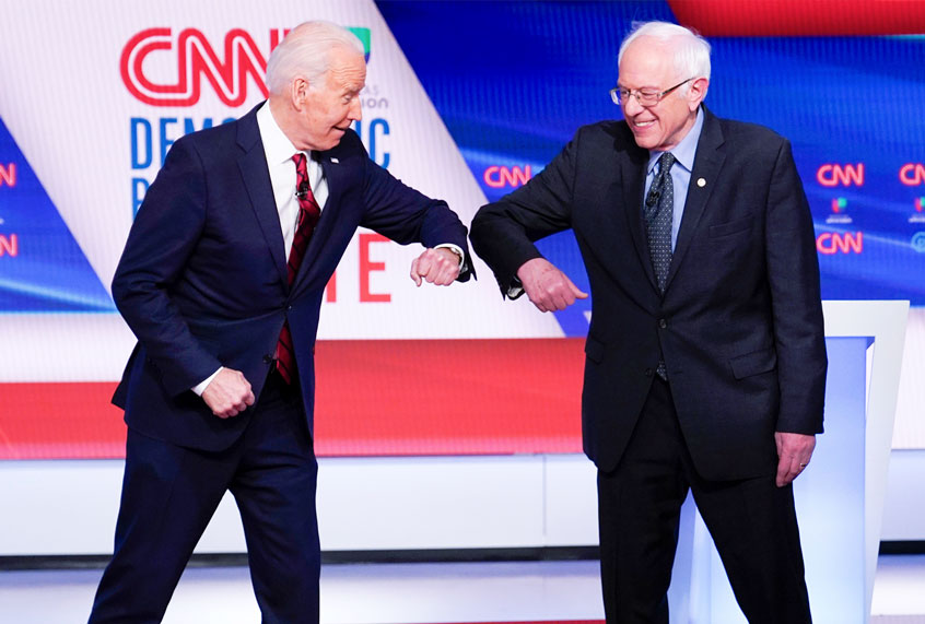 Former Vice President Joe Biden, left, and Sen. Bernie Sanders, I-Vt., right, greet one another before they participate in a Democratic presidential primary debate at CNN Studios in Washington, Sunday, March 15, 2020. (AP Photo/Evan Vucci)