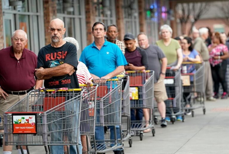 Some of the more than 150 people in line wait for an grocery store to open Tuesday, March 17, 2020 (AP Photo/David J. Phillip)