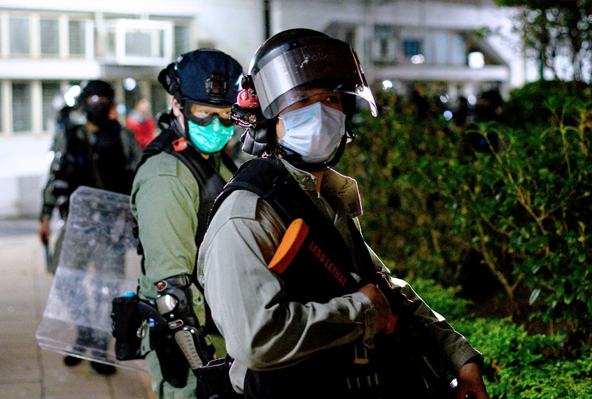 Riot police officers wearing face masks stand guard as residents protest against plans for an empty local housing estate to become a temporary quarantine camp for patients and frontline medical staff of a SARS-like virus outbreak which began in the Chinese city of Wuhan, in the Fanling district in Hong Kong on January 26, 2020. - Protesters threw petrol bombs on January 26 night at an empty public housing complex in Hong Kong that had been earmarked to become a temporary quarantine zone as the city battles the outbreak of a SARS-like virus. (PHILIP FONG/AFP via Getty Images)