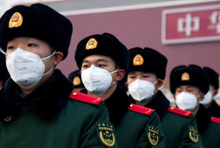 Chinese police officers wearing masks stand in front of the Tiananmen Gate (Betsy Joles/Getty Images)