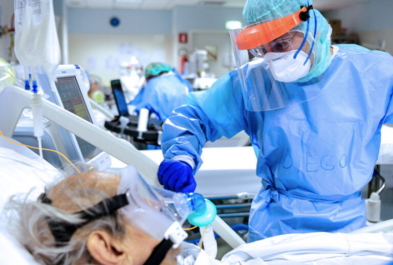 A member of the medical staff comforts a patient infected by the novel coronavirus (PIERO CRUCIATTI/AFP/Getty Images)