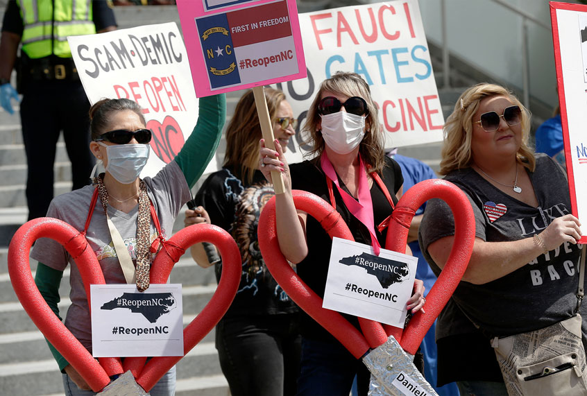 People gather near the North Carolina Legislative Building to protest the current stay-at-home orders issued by Gov. Roy Cooper amid the coronavirus outbreak in Raleigh, N.C., Tuesday, April 28, 2020. (AP Photo/Gerry Broome)