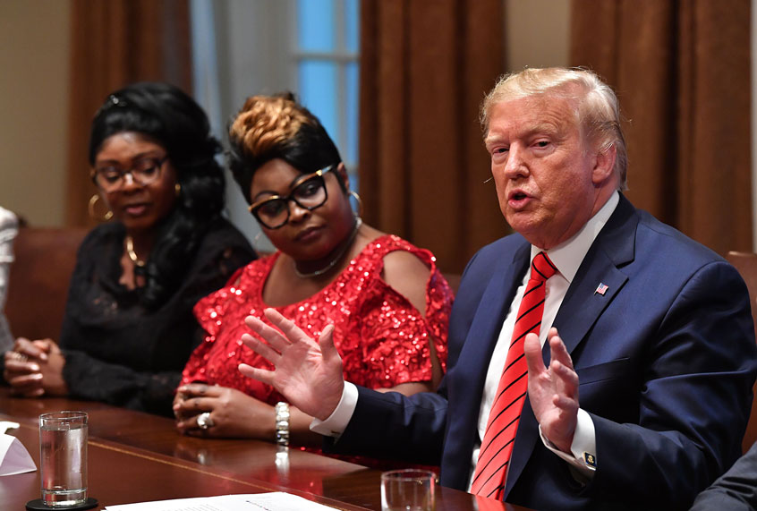 US President Donald Trump speaks as social media personalities Lynnette Hardaway (L) and Rochelle Richardson (2-L), otherwise known as Diamond and Silk listen (NICHOLAS KAMM/AFP via Getty Images)