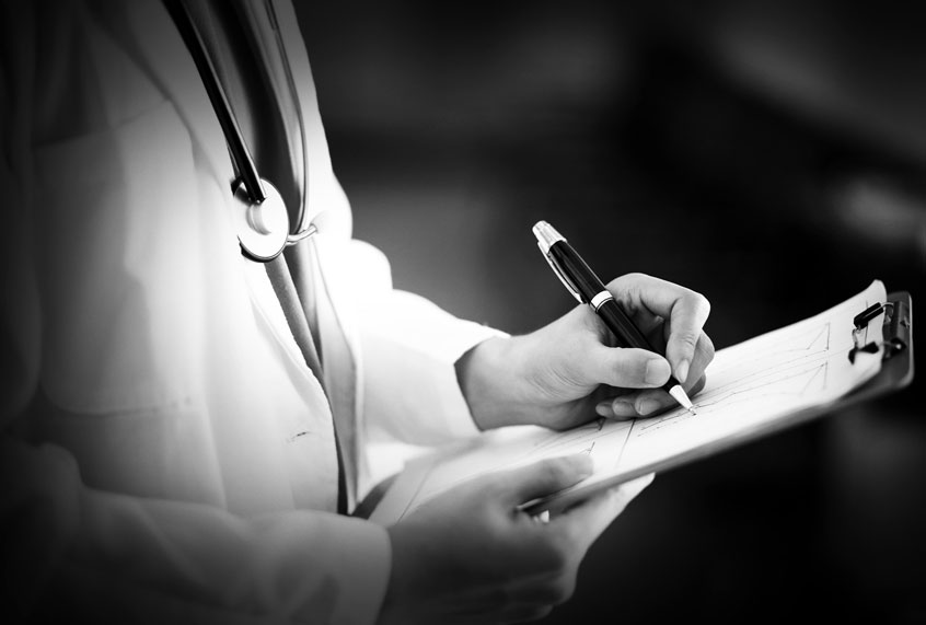 Doctor writing on clipboard (Getty Images)