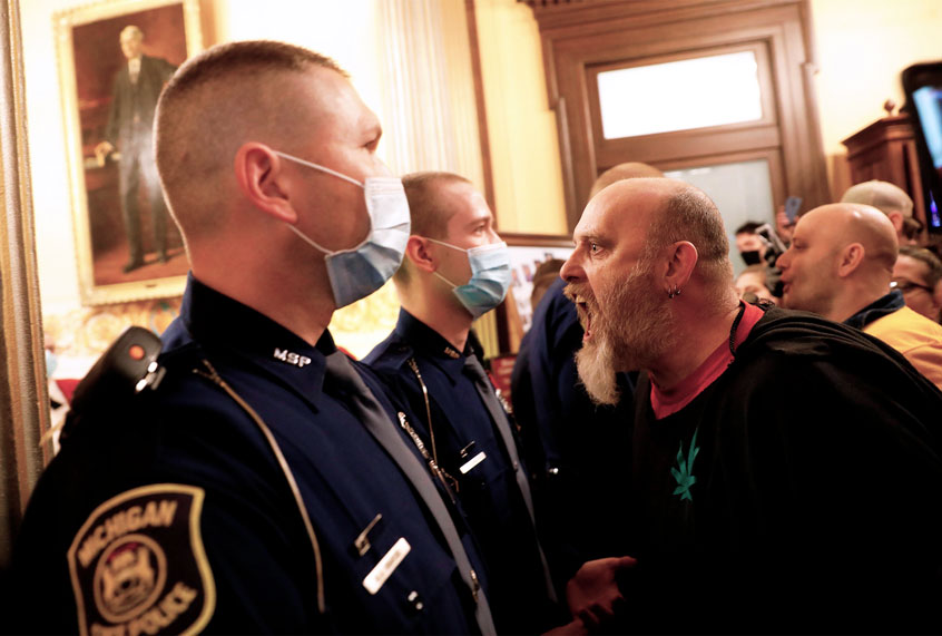 Protestors try to enter the Michigan House of Representative chamber and are being kept out by the Michigan State Police (EFF KOWALSKY/AFP via Getty Images)