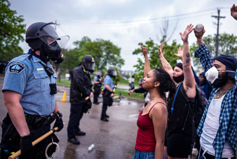 People face off with police near the Minneapolis 3rd Police Precinct. (Richard Tsong-Taatarii/Star Tribune via Getty Images))