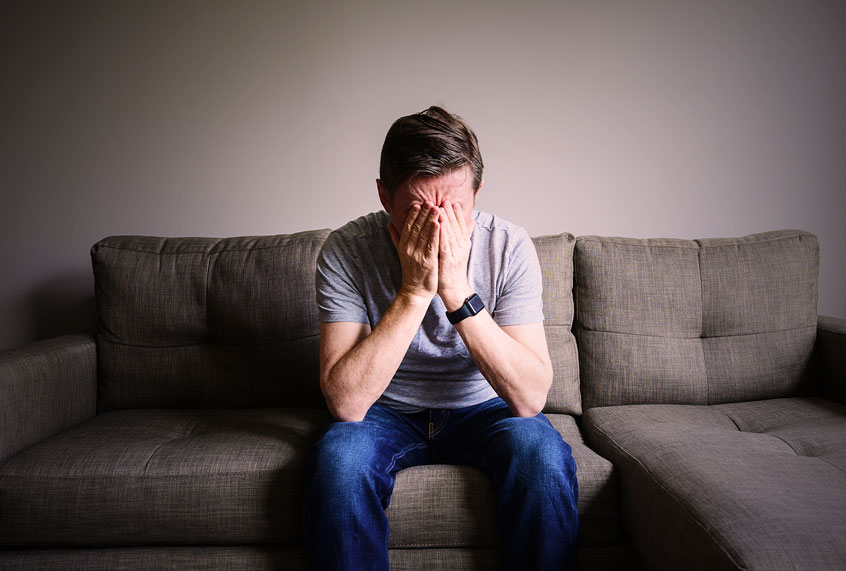 Stressed mature man sitting on couch (Getty Images)