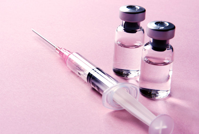 A studio shot of two glass vials with medicine and a single syringe ready for an injection or vaccination (Getty Images)