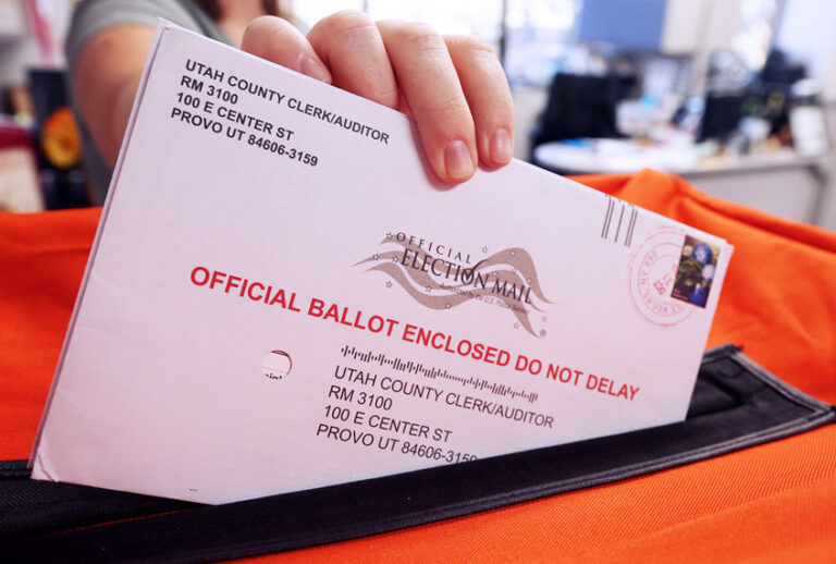 Election office puts mail in ballots into a container (George Frey/Getty Images)