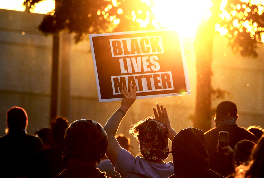 A protestor holds a Black Lives Matter placard (CHANDAN KHANNA/AFP via Getty Images)