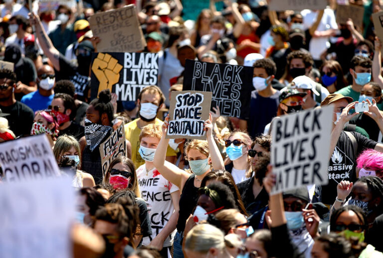 People hold placards as they join a spontaneous Black Lives Matter march to protest the death of George Floyd in Minneapolis (Hollie Adams/Getty Images)