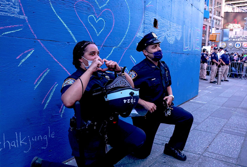 Two police officers take a knee during a demonstration by protesters in Times Square over the death of George Floyd by a Minneapolis police officer (BRYAN R. SMITH/AFP via Getty Images)