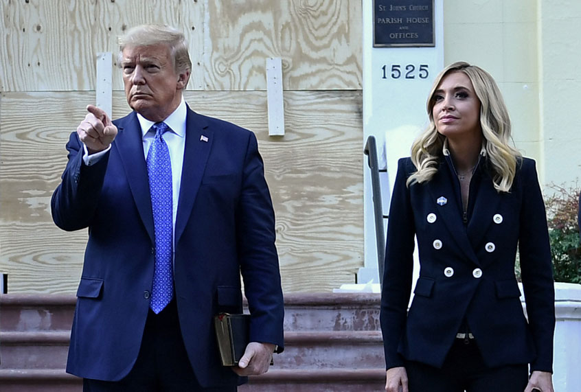 US President Donald Trump holds up a Bible as he gestures, alongside White House press secretary Kayleigh McEnany, outside of St John's Episcopal church across Lafayette Park in Washington, DC on June 1, 2020 (BRENDAN SMIALOWSKI/AFP via Getty Images)