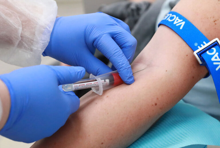 A healthcare worker takes blood samples from a person (Sergei FadeichevTASS via Getty Images)