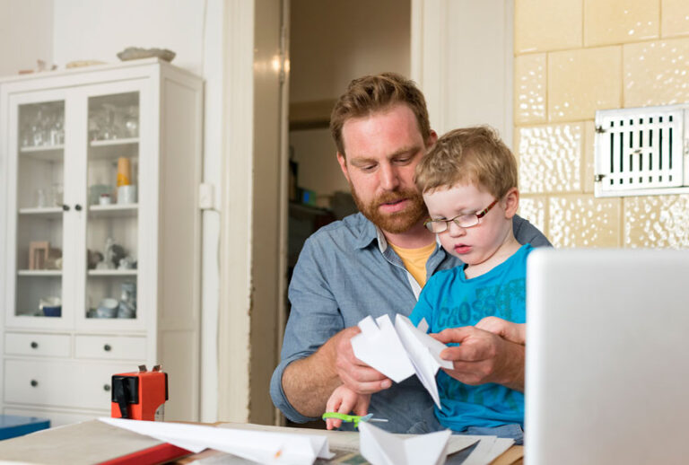 Father and toddler son making paper plane at home (Getty Images)