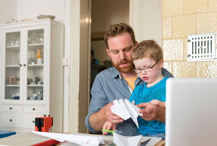 Father and toddler son making paper plane at home (Getty Images)