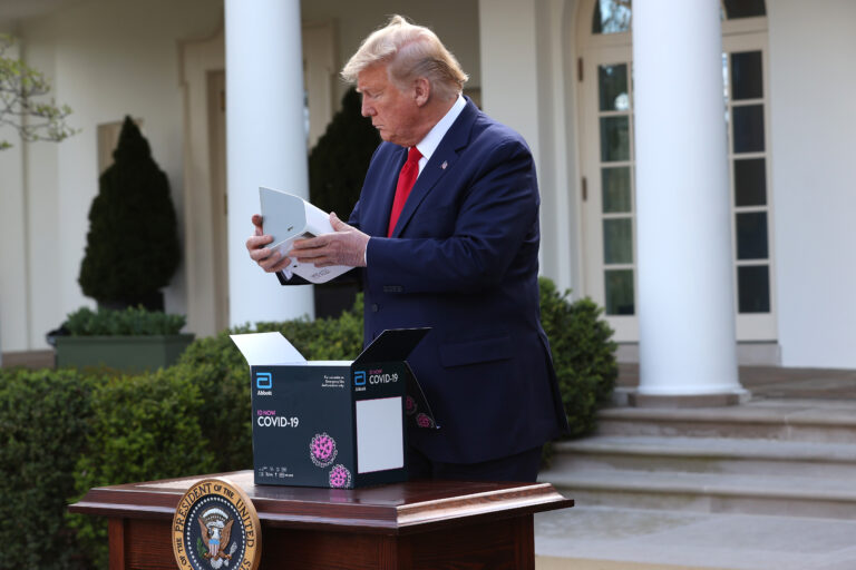 MARCH 30: U.S. President Donald Trump takes a new COVID-19 test kit developed by Abbott Labs out of its box during the daily coronavirus briefing at the Rose Garden of the White House on March 30, 2020 in Washington, DC. (Photo by Win McNamee/Getty Images)