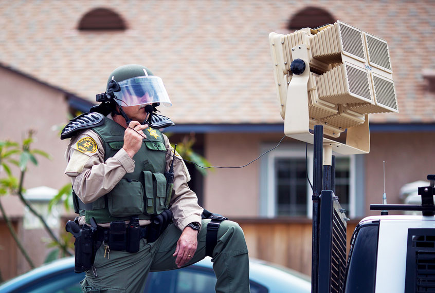 A Sheriffs deputy in riot gear stands ready to use a sound cannon, or Long Range Acoustic Device (LRAD), against protesters (David McNew/Getty Images)