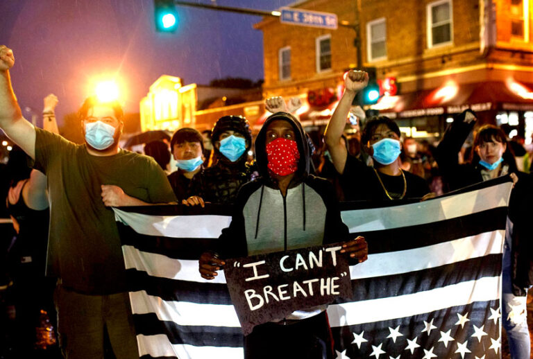 People hold up their fists after protesting near the spot where George Floyd died while in custody of the Minneapolis Police (KEREM YUCEL/AFP via Getty Images)