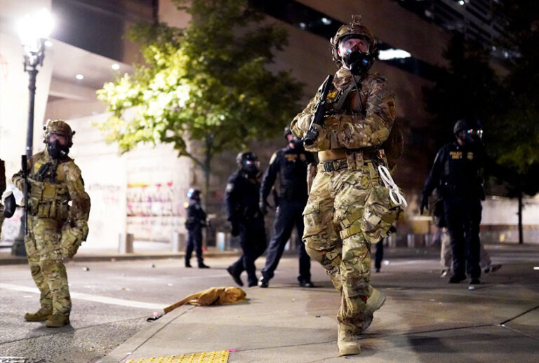 A federal officer watches a crowd of protesters during a standoff between the two groups at the Mark O. Hatfield U.S. Courthouse on July 21, 2020 in Portland, Oregon. State and elected officials have called for the federal officers to leave Portland as clashes between protesters and federal police continue to escalate. (Nathan Howard/Getty Images)