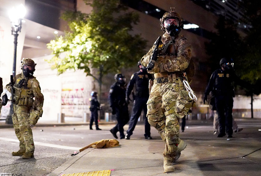 A federal officer watches a crowd of protesters during a standoff between the two groups at the Mark O. Hatfield U.S. Courthouse on July 21, 2020 in Portland, Oregon. State and elected officials have called for the federal officers to leave Portland as clashes between protesters and federal police continue to escalate. (Nathan Howard/Getty Images)
