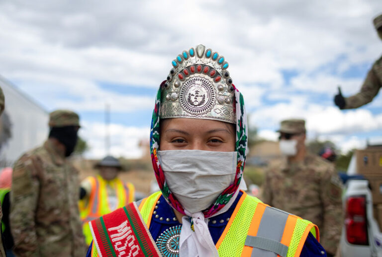 Miss Navajo Nation Shaandiin P. Parrish puts on a white gown to help distribute food, water, and other supplies to Navajo families on May 27, 2020 in Huerfano on the Navajo Nation Reservation, New Mexico. Encompassing parts of Utah, Arizona, and New Mexico, the Navajo Nation now has the highest number of positive COVID-19 cases per capita in the United States, as the spread of the coronavirus continues to disproportionately effect minority communities across the country. (Sharon Chischilly/Getty Images)