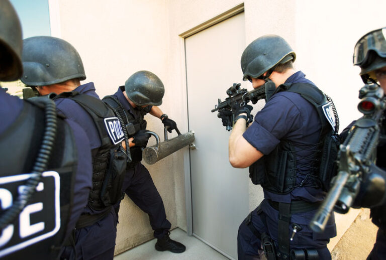 Police officers breaking down doors (Getty Images)