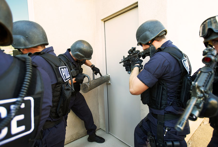 Police officers breaking down doors (Getty Images)