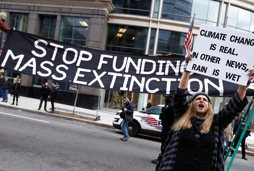 Demonstrates protest during "Fire Drill Friday" climate change protest on December 6, 2019 in Washington, DC. Speakers address the ways in which climate change affects migration and human rights. The movement demands fast action for a "Green New Deal," including renewable energy by 2030, and no new exploration or drilling for fossil fuels, including the end to taxpayer subsidies to oil companies. (John Lamparski/Getty Images)