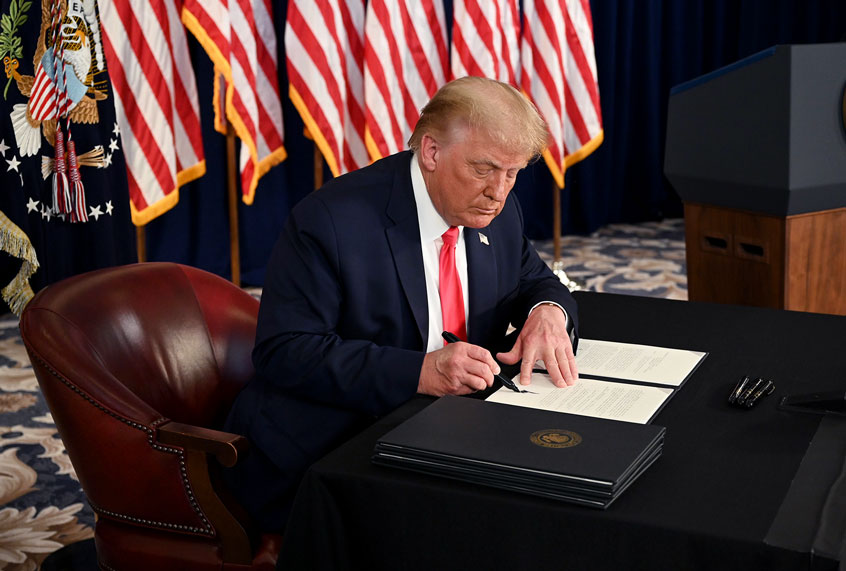 US President Donald Trump signs executive orders during a news conference in Bedminster, New Jersey, on August 8, 2020. (JIM WATSON/AFP via Getty Images)