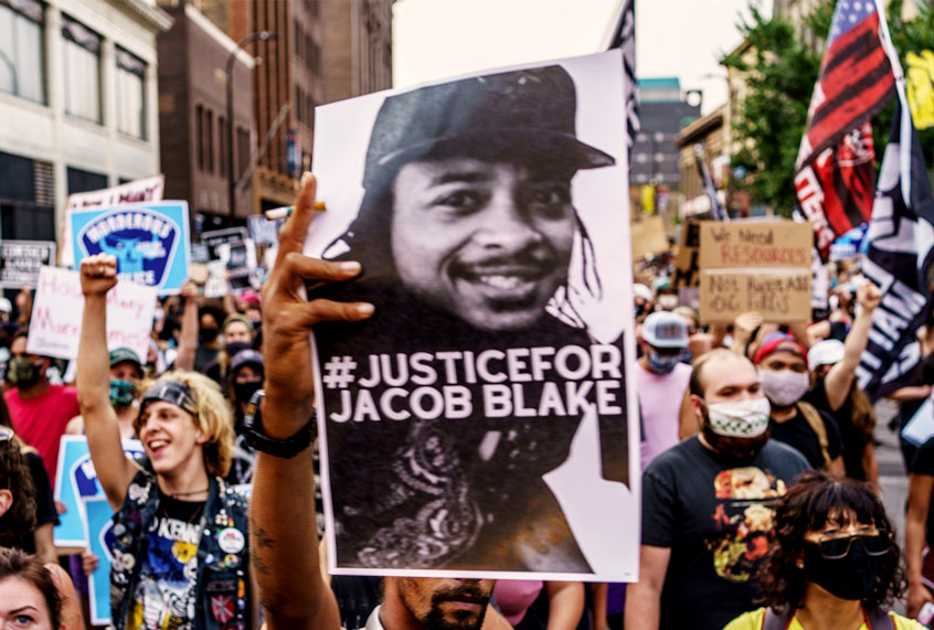 Protesters march near the Minneapolis 1st Police precinct during a demonstration against police brutality and racism on August 24, 2020 in Minneapolis, Minnesota. - It was the second day of demonstrations in Kenosha after video circulated Sunday showing the shooting of Jacob Blake -- multiple times, in the back, as he tried to get in his car, with his three children watching. (KEREM YUCEL/AFP via Getty Images)