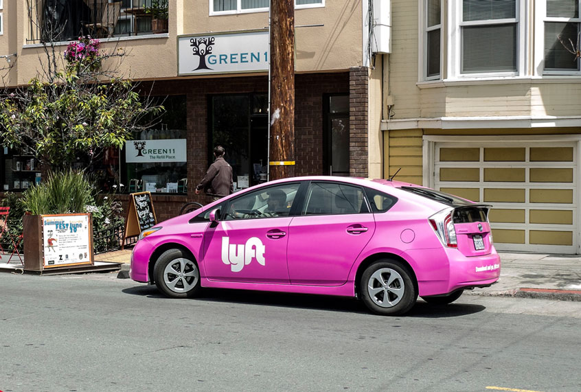 A Lyft branded car service picks up a passenger in San Francisco, CA (Ramin Talaie/Corbis via Getty Images)
