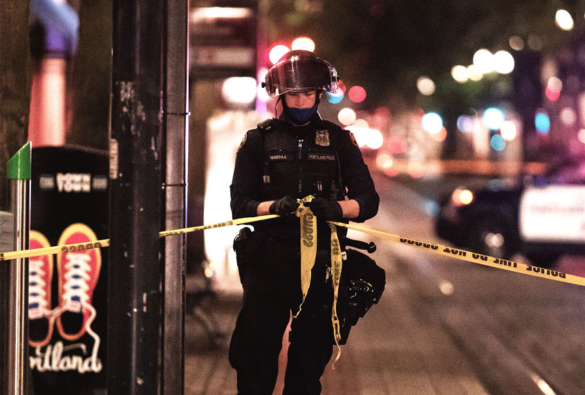A Portland police officer ties a police line around the scene of a fatal shooting near a pro-Trump rally on August 29, 2020 in Portland, Oregon. Far left counter-protesters and pro-Trump supporters clashed Saturday afternoon as a parade of cars carrying right wing supporters made their way from nearby Clackamas to Portland. (Nathan Howard/Getty Images)