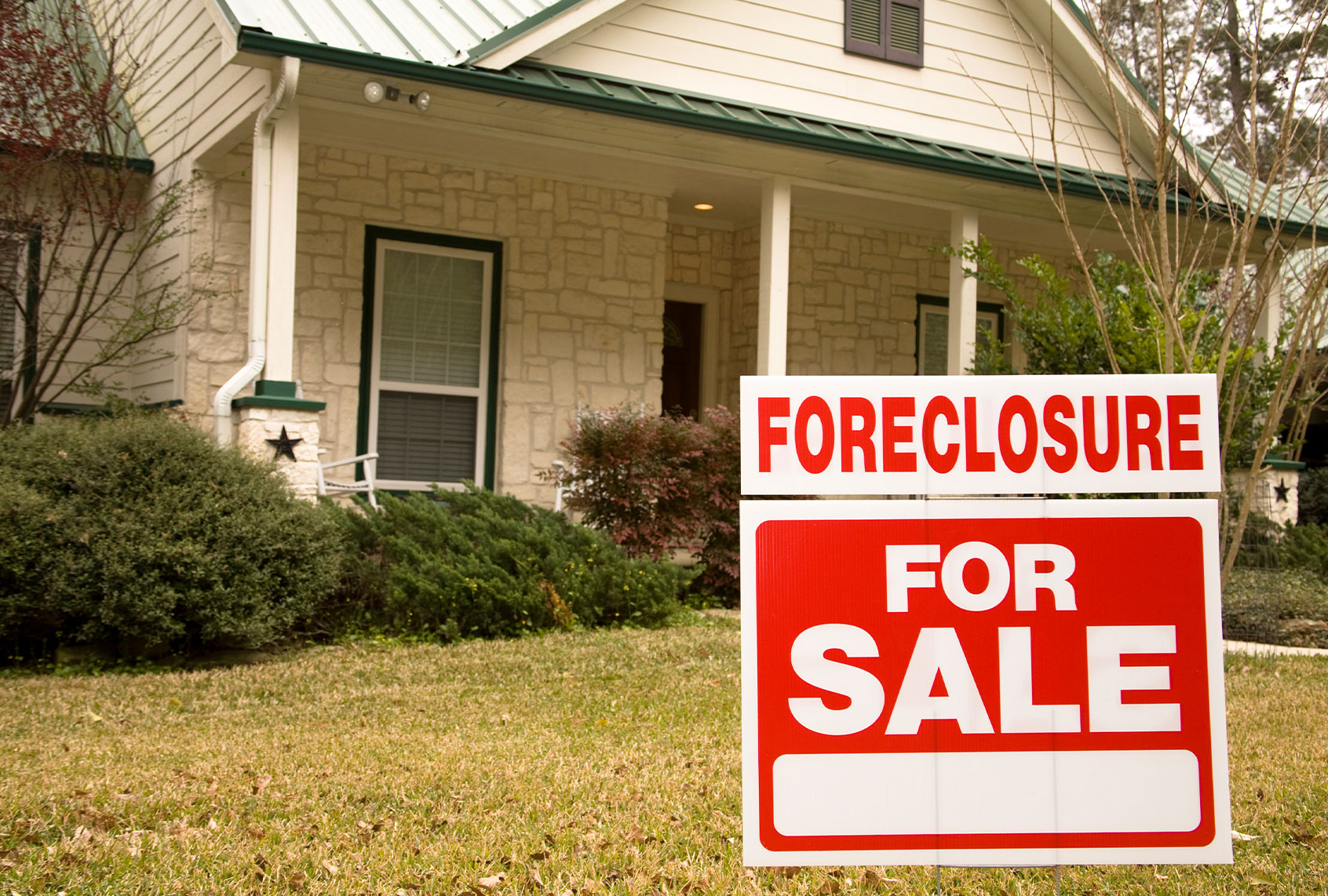 Foreclosure for sale sign in front of house (Getty Images)