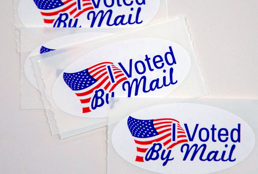 Stickers that read "I Voted By Mail" sit on a table waiting to be stuffed into envelopes by absentee ballot election workers at the Mecklenburg County Board of Elections office in Charlotte, NC on September 4, 2020 (LOGAN CYRUS/AFP via Getty Images))