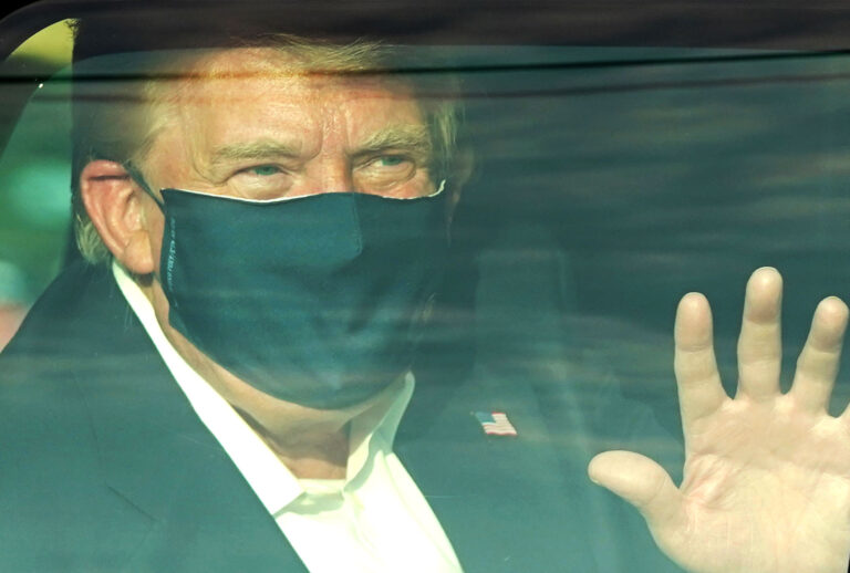 A car with US President Trump drives past supporters in a motorcade outside of Walter Reed Medical Center in Bethesda, Maryland on October 4, 2020. - US President Donald Trump drove past supporters outside the hospital where he was being treated for Covid-19, after announcing on Twitter a "suprise visit" to his backers. (ALEX EDELMAN/AFP via Getty Images)
