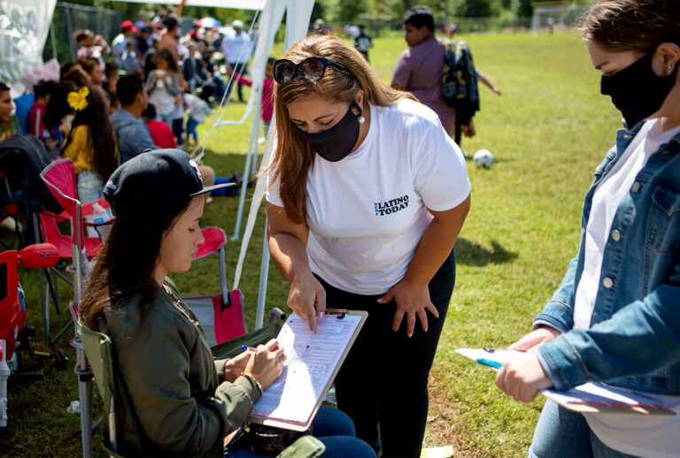 Sandra Amado Gomez and her daughter Aylen Agostina Gomez registers a woman to vote during halftime at the championship game of soccer on Sunday, Sept. 20, 2020 in Raleigh, NC. North Carolina is gearing up to be a swing state in the 2020 election and Latino voters will play a big part in the outcome. (Jason Armond / Los Angeles Times via Getty Images)