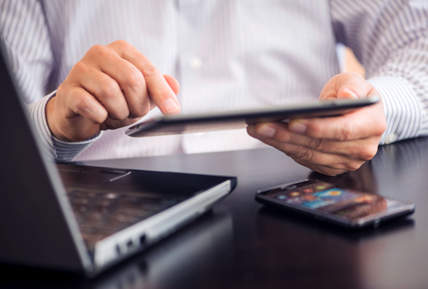 Man using tablet pc, laptop and smartphone (Getty Images)