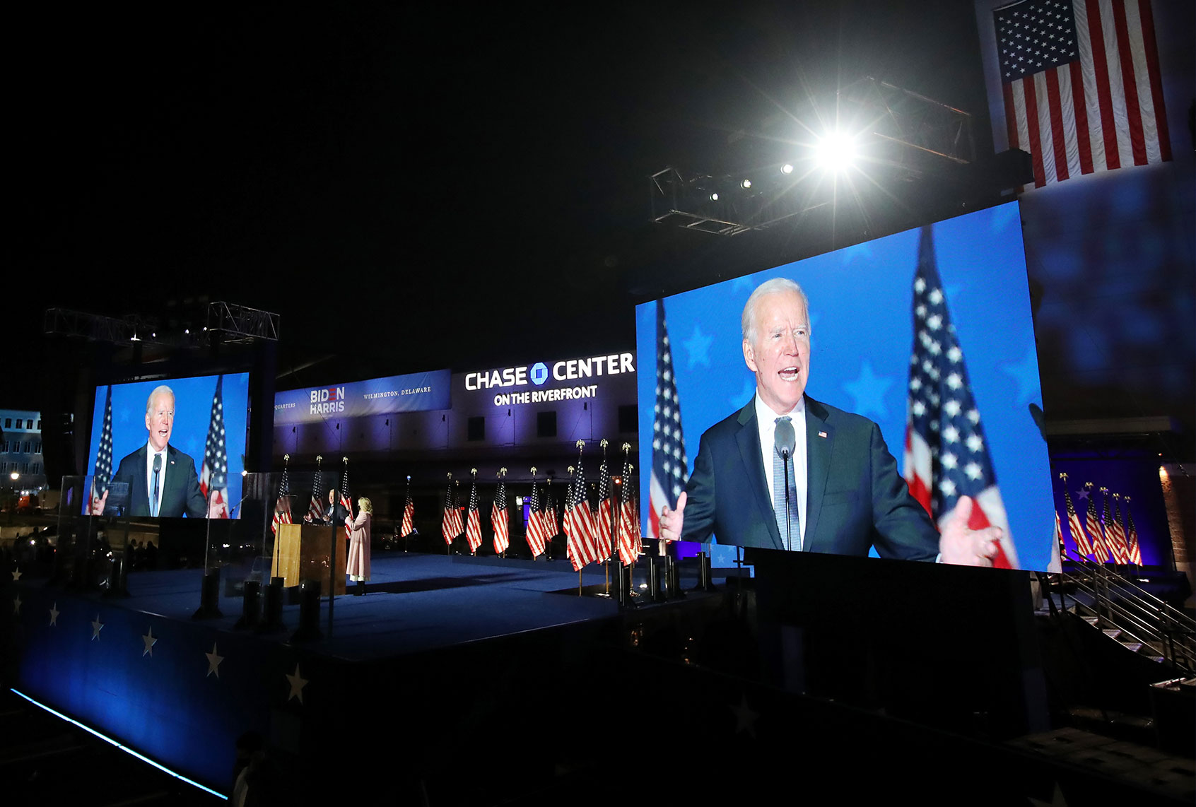 Democratic presidential nominee Joe Biden speaks at a drive-in election night event as Dr. Jill Biden looks on at the Chase Center in the early morning hours of November 04, 2020 in Wilmington, Delaware. Biden spoke shortly after midnight with the presidential race against Donald Trump still too close to call. (Win McNamee/Getty Images)