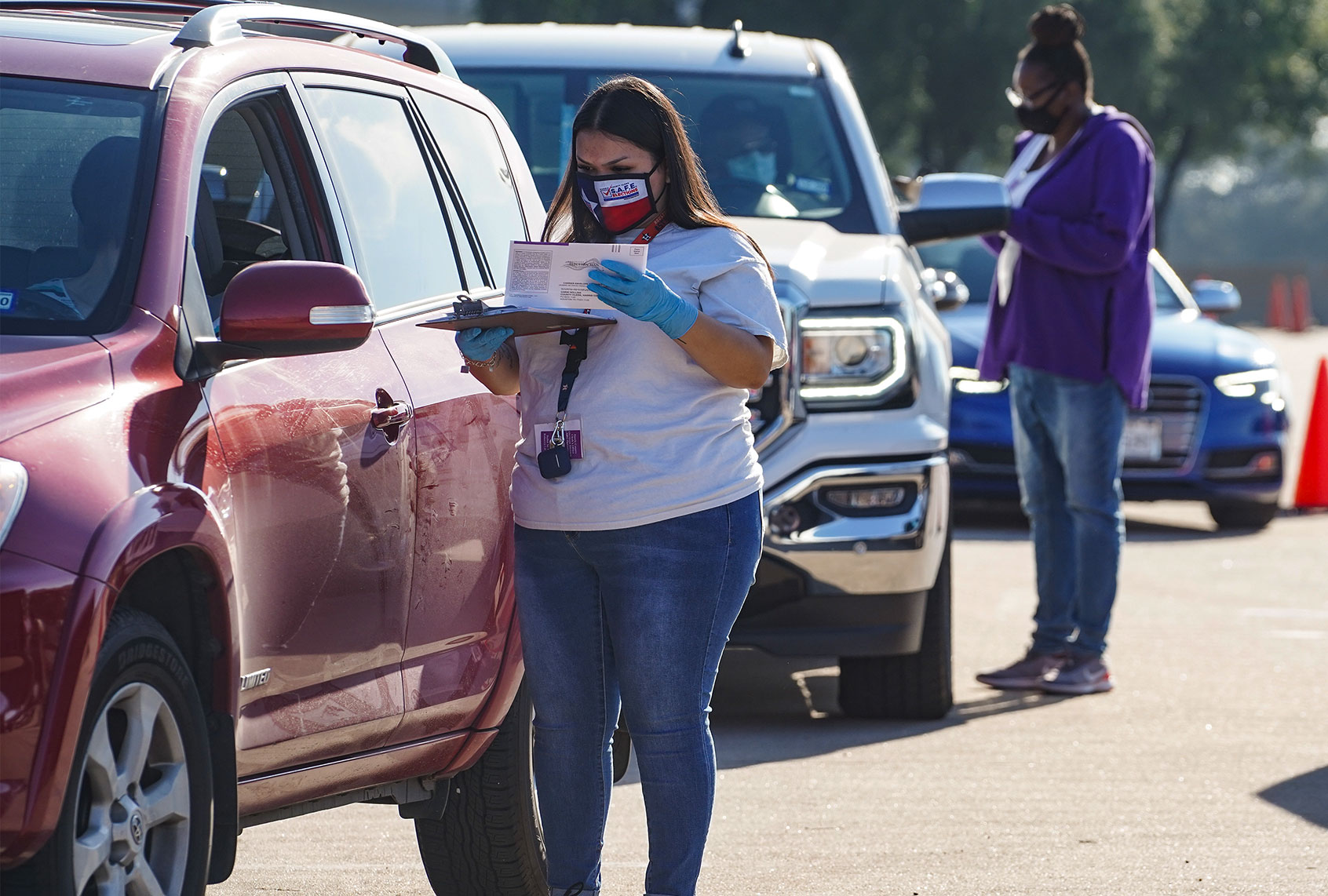 Election workers accept mail in ballot from voters at drive-through mail ballot drop off site at NRG Stadium on October 7, 2020 in Houston, Texas. Gov. Gregg Abbott issued an executive order limiting each Texan county to one mail ballot drop-off site due to the pandemic. (Go Nakamura/Getty Images)