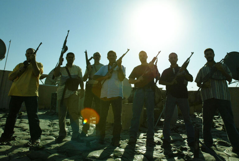 Members of a private security company pose on the rooftop of a house in Baghdad, 18 September 2007. Iraq declared today it will review the operations of all security firms working in the war-ravaged country following a deadly shootout involving private US contractor Blackwater. (PATRICK BAZ/AFP via Getty Images)