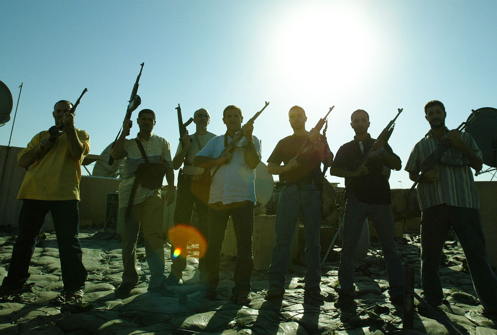 Members of a private security company pose on the rooftop of a house in Baghdad, 18 September 2007. Iraq declared today it will review the operations of all security firms working in the war-ravaged country following a deadly shootout involving private US contractor Blackwater. (PATRICK BAZ/AFP via Getty Images)