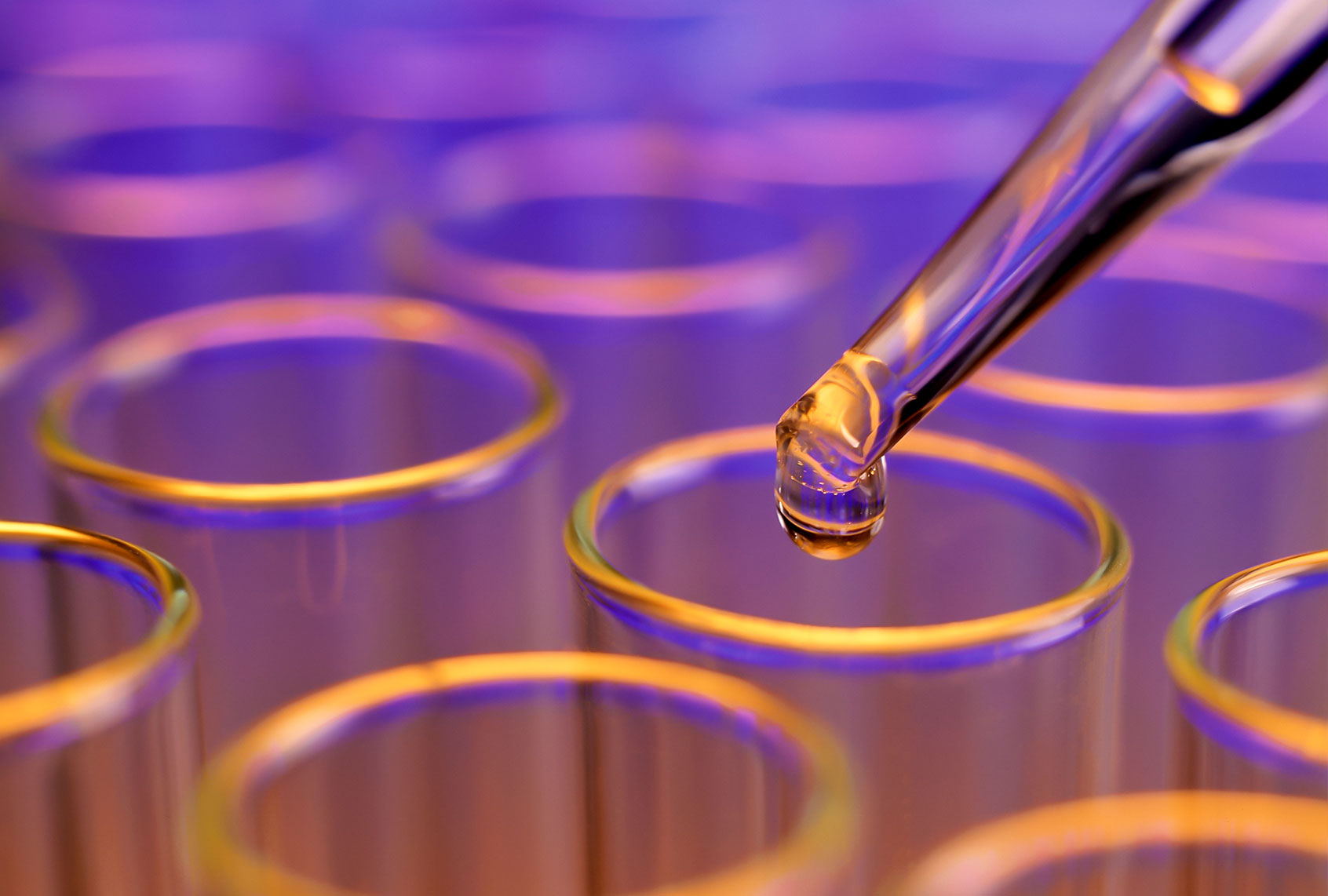 Liquid drop falling into test tubes (Getty Images)